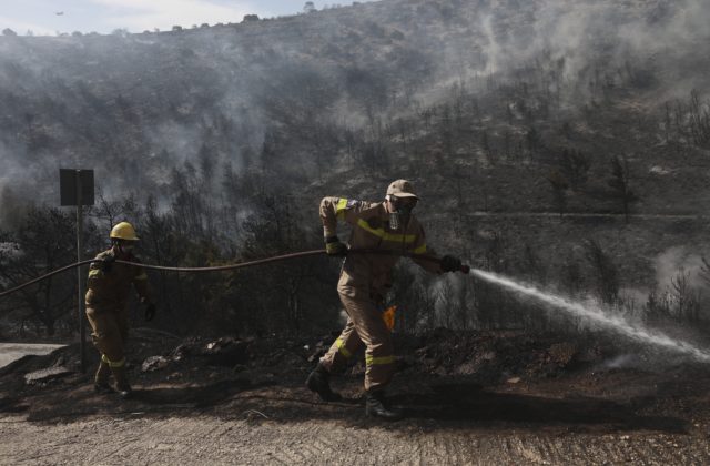 Grécki hasiči bojujú naďalej s lesným požiarom, poškodené sú domy aj autá