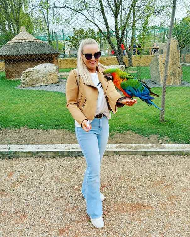 žena s papagájom v ruke